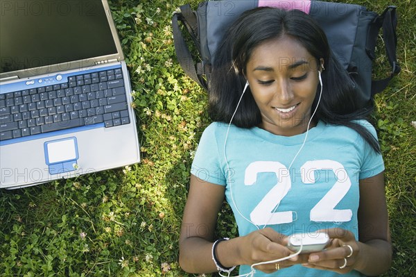 Indian female college student listening to mp3 player