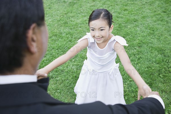 Asian father and daughter holding hands