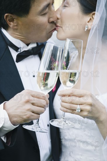 Asian newlyweds kissing