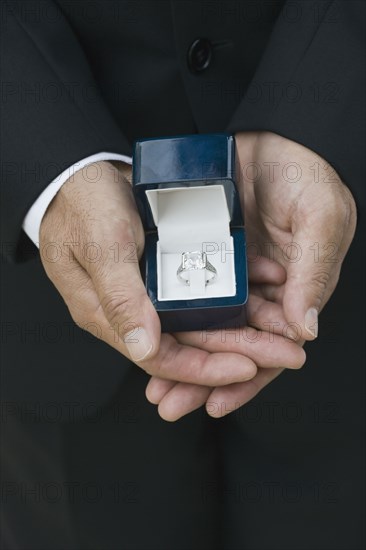 Asian man holding engagement ring