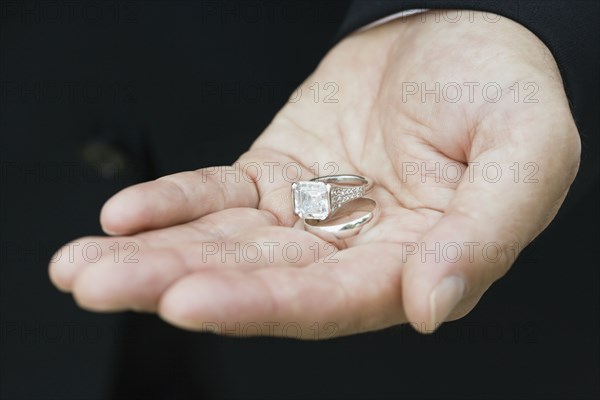 Asian man holding wedding rings