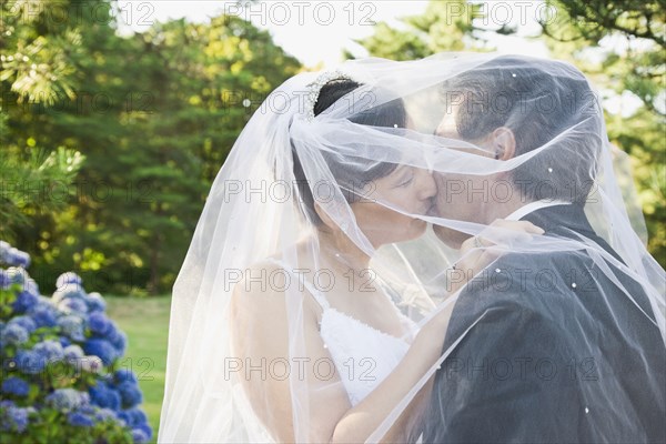 Asian newlyweds kissing