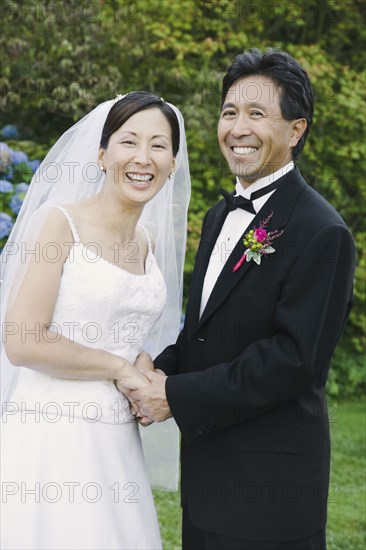 Asian newlyweds holding hands