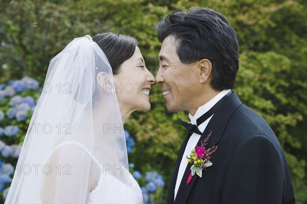 Asian newlyweds smiling at each other