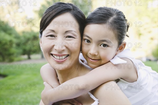 Asian bride and flower girl hugging