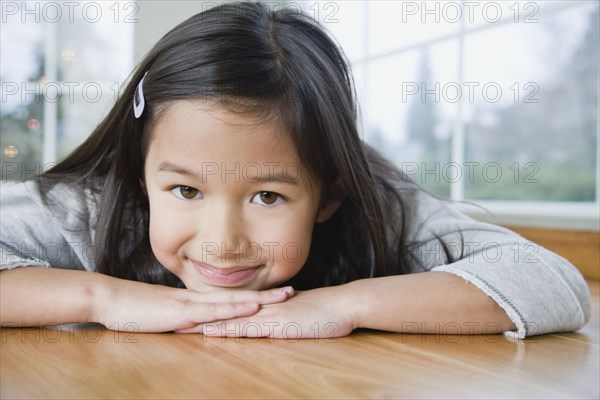 Mixed Race girl resting chin on hands