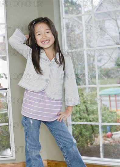 Mixed Race girl posing next to window