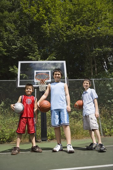 Asian brothers holding basketballs