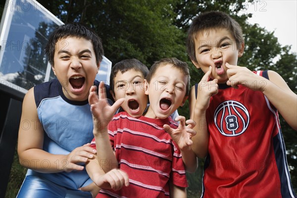 Asian brothers yelling on basketball court