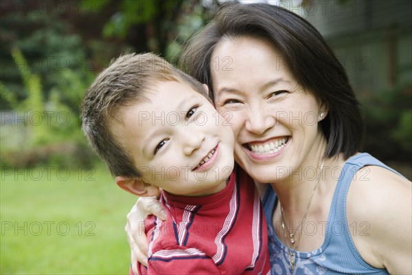 Asian mother and son hugging
