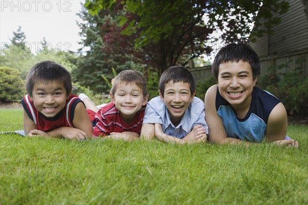 Asian brothers laying in grass