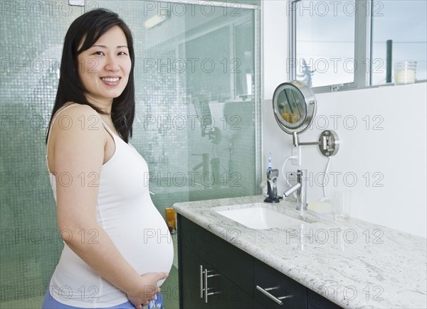 Pregnant Asian woman in bathroom