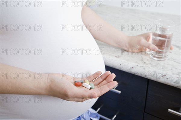 Pregnant Asian woman taking vitamins