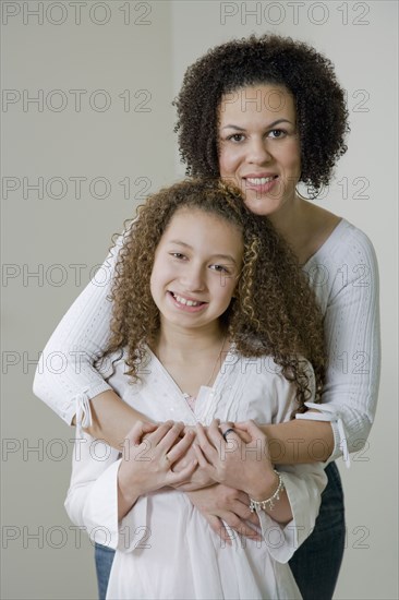 Mixed race mother and daughter hugging