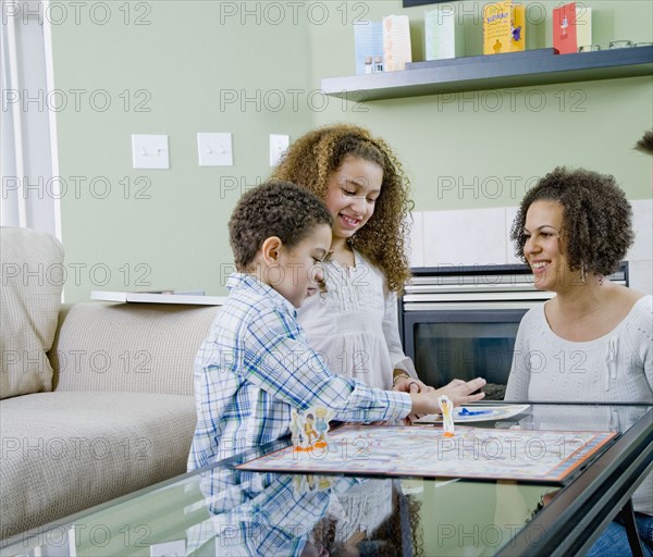 Mixed race family playing board game