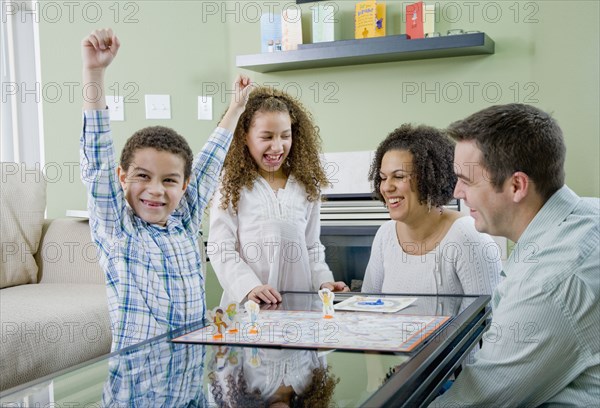 Mixed race family playing board game