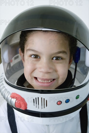 Mixed race boy in astronaut costume