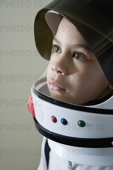 Mixed race boy in astronaut costume