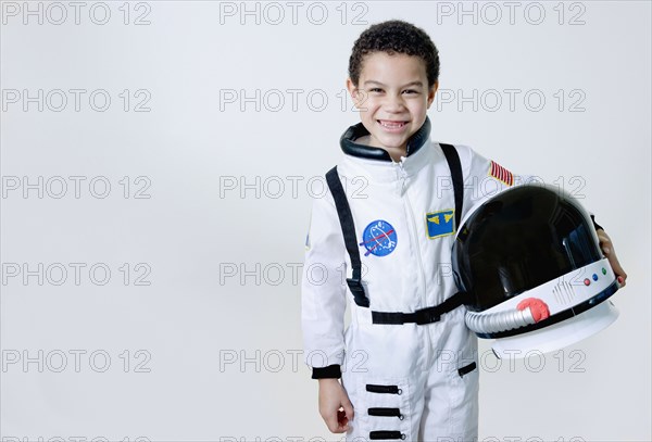 Mixed race boy in astronaut costume