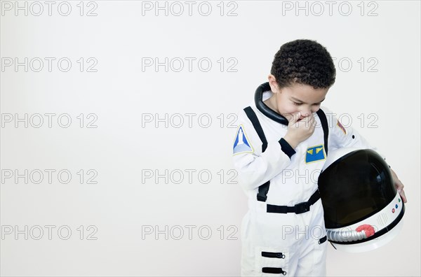 Mixed race boy in astronaut costume