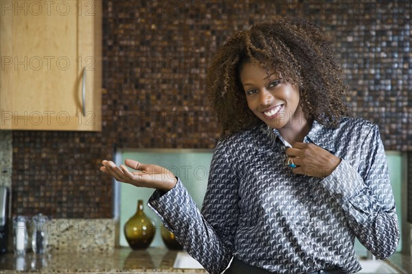 Proud African woman showing off modern kitchen