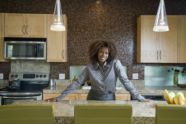 Confident African woman standing in modern kitchen