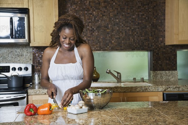 African woman fixing healthy meal in modern kitchen