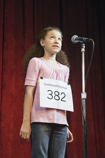 Mixed race girl competing in spelling bee