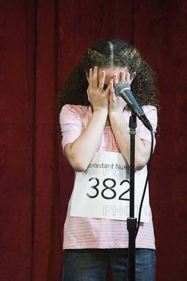 Mixed race girl competing in spelling bee