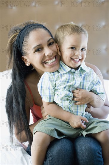 Happy mother holding son on lap