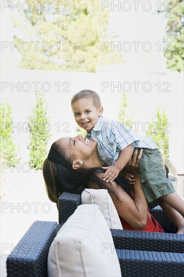 Mother hugging son on patio