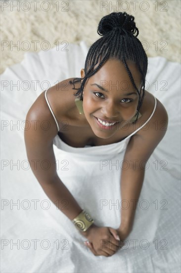 Mixed race woman in white dress looking up