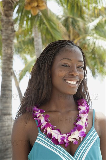 African woman wearing lei on beach