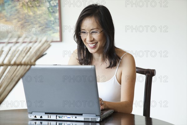 Japanese woman using laptop at table