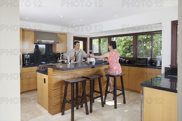 Japanese couple drinking wine in kitchen