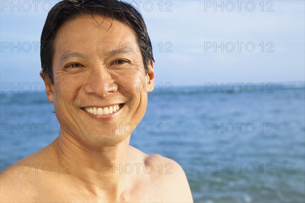 Japanese man smiling on beach