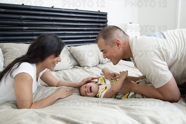 Family playing on bed in bedroom