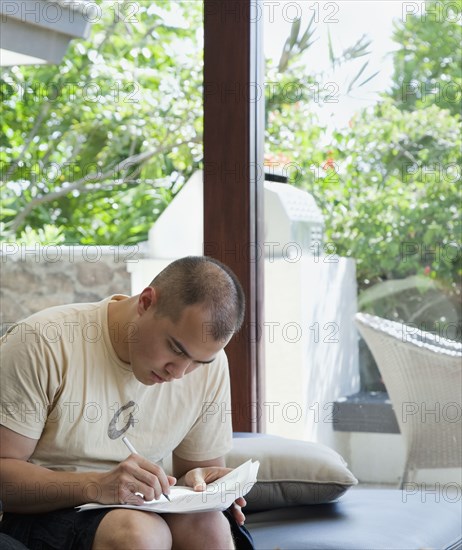 Mixed race man filling out forms