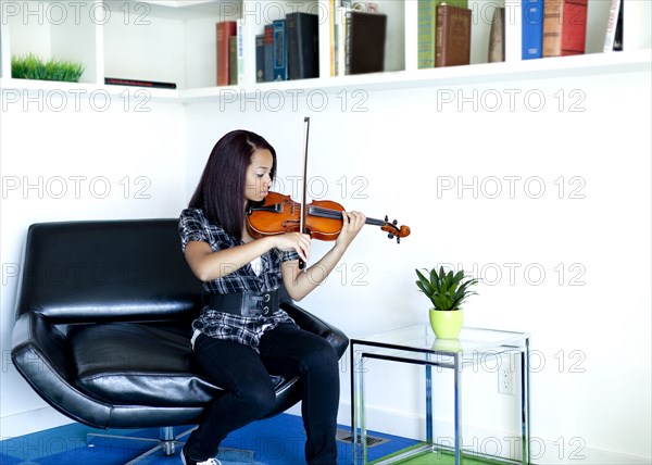 Mixed race girl practicing violin