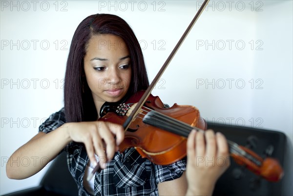 Mixed race girl practicing violin