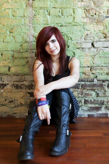 Redheaded teenager leaning against wall