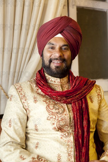 Smiling mixed race man in traditional Indian clothing