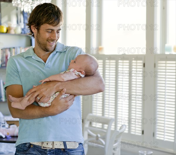 Happy Caucasian father holding baby daughter