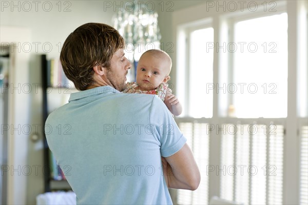 Happy Caucasian father holding baby daughter