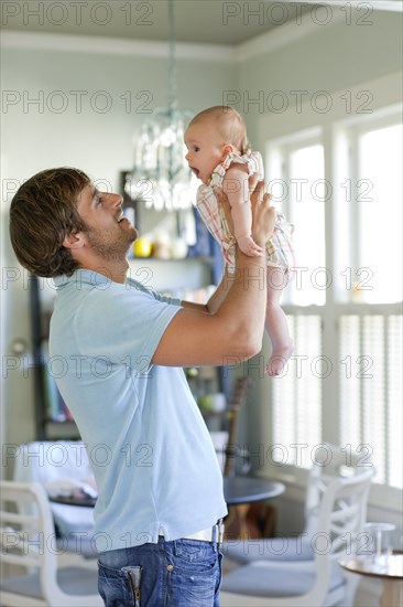 Happy Caucasian father holding baby daughter