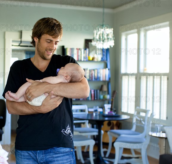 Happy Caucasian father holding baby daughter