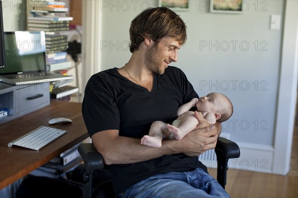 Happy Caucasian father holding baby daughter