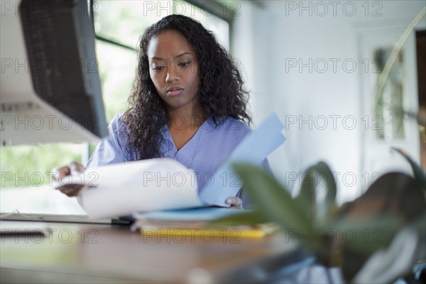 Mixed race woman looking at paperwork