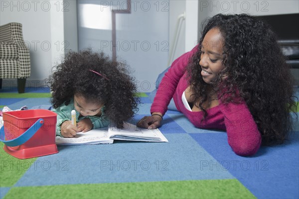 Mixed race mother watching daughter color