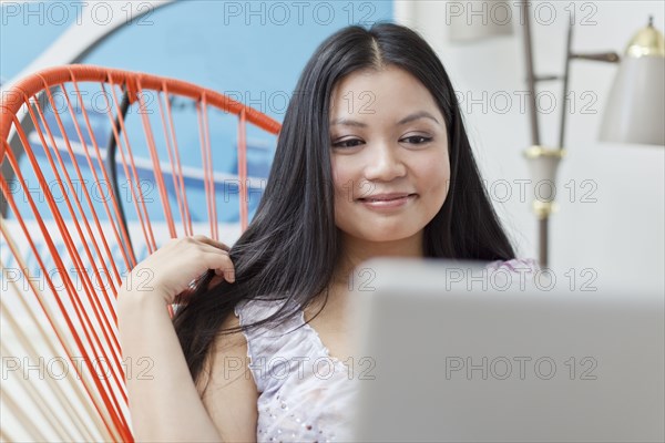 Smiling Vietnamese woman using laptop